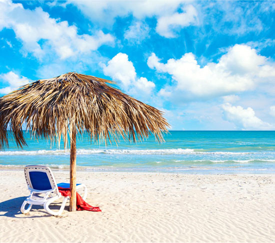 straw umbrella and lounge chair on a Cuban beach